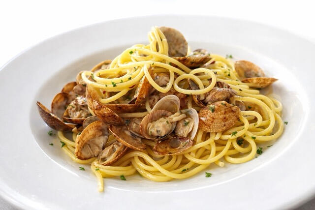 Spaghetti alle Vongole with Fresh Sardinian Clams at Trattoria Locanda Stella, Monti Plate of spaghetti alle vongole with fresh local clams and parsley, a signature dish at Trattoria Locanda Stella in Monti, Sardinia.